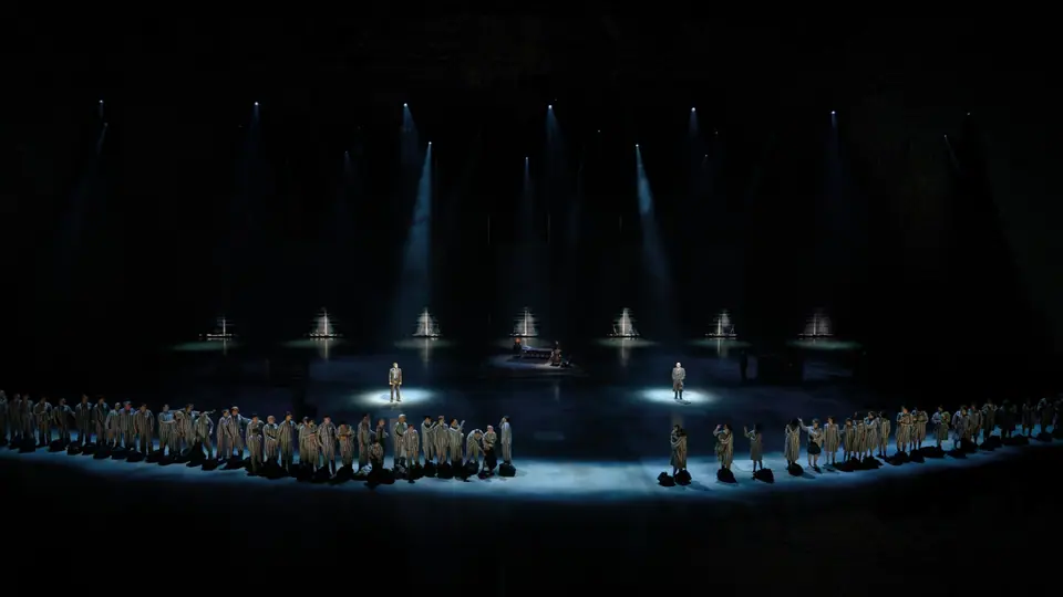 40-45 de musical: gevangenen in een halve cirkel, twee spelers in een spot, lichtbundels van boven