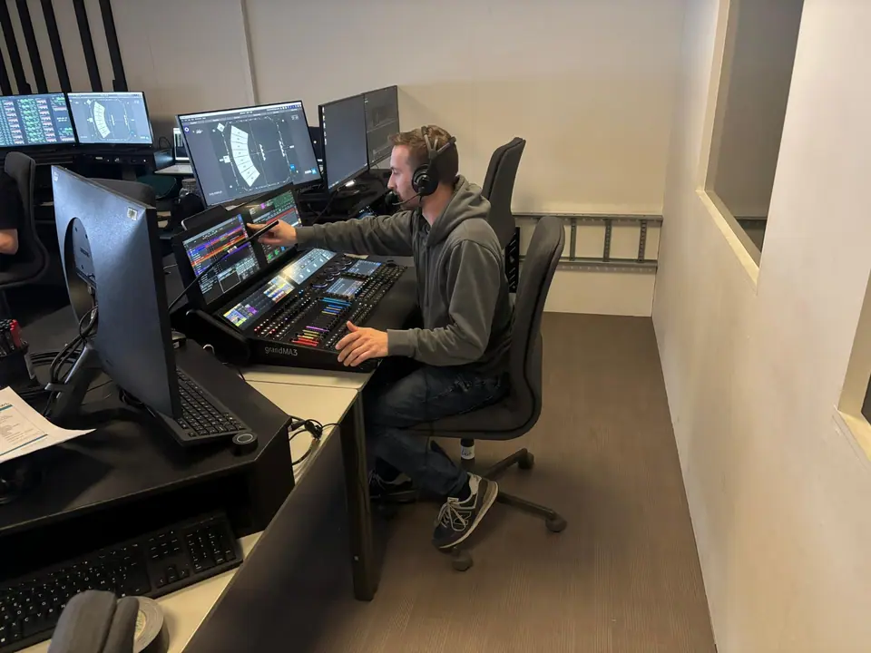 Paul Heijkens bedient 40-45 de musical op een grandMA3, met headset, de visualisatie op het scherm erachter
