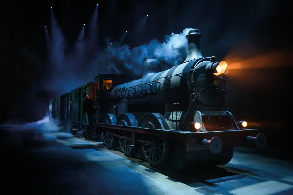 40-45 de musical: stoomtrein op het podium in blauw licht en rook, oranje koplamp
