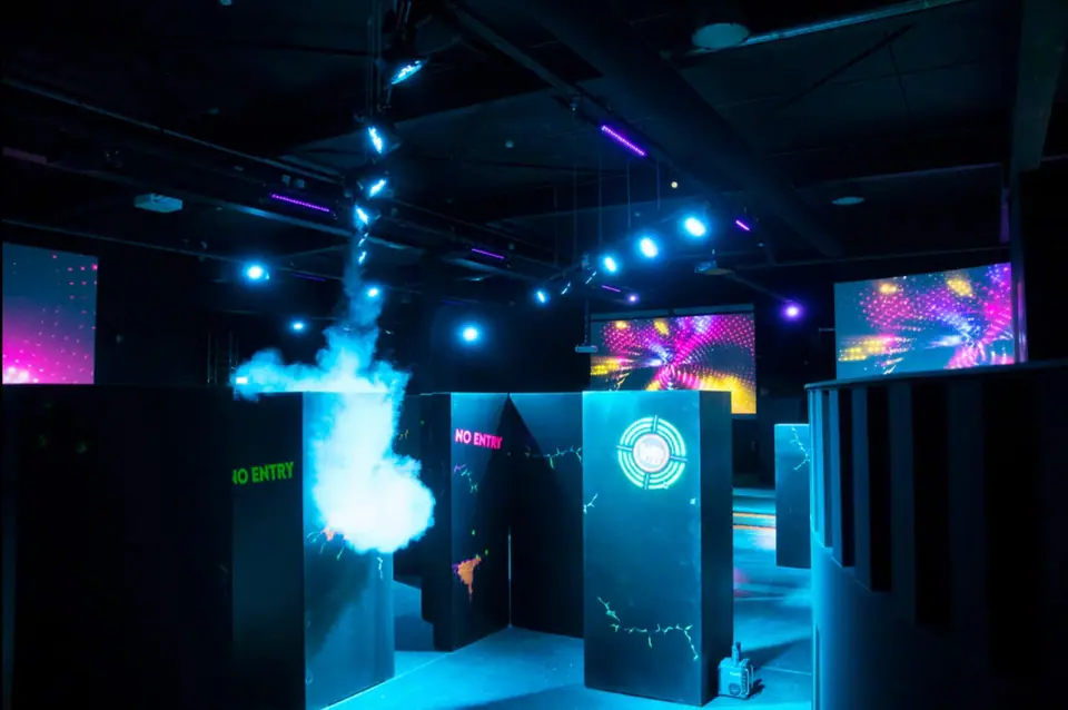 Lasergame-arena bij Bart & Bites: rookwolk tussen de wanden, blauwe spots aan het plafond en projecties op de achterwanden