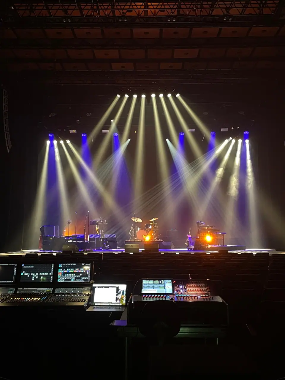 Cuby's Blues 2023: zicht vanaf de FOH met grandMA3 en geluidstafel op een podium in wit en blauw licht