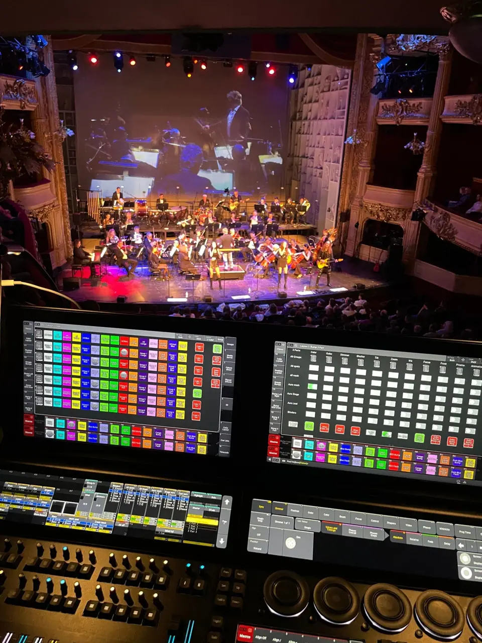 Rock the Opera vanaf de lichttafel: grandMA3-schermen op de voorgrond, het orkest op het podium erachter