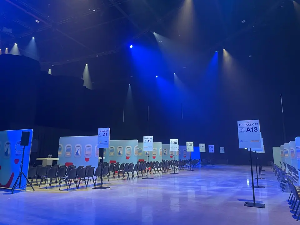 TUI Take Off 2026: gates A1 tot A13 met stoelen en vliegtuigramen, in blauw licht
